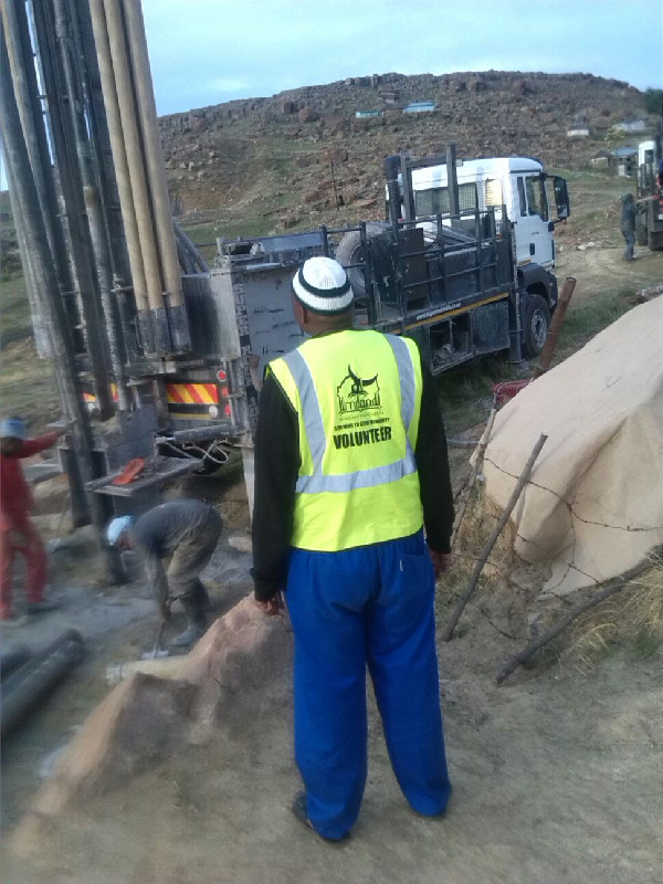 An Al-Imdaad Foundation volunteer monitors the drilling process at the borehole site